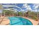 Inviting backyard pool enclosed by a screened lanai, surrounded by lush tropical landscaping at 6583 Waterford Cir, Sarasota, FL 34238