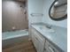 Bathroom featuring tub with tiled wall, white vanity with marble countertop and decorative framed mirror at 6912 10Th W Ave, Bradenton, FL 34209