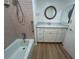 Bathroom with a tub, shower and white vanity with drawers and cabinets, and an oval mirror at 6912 10Th W Ave, Bradenton, FL 34209