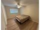 This bedroom has a ceiling fan and a window providing natural light, complemented by wood-look flooring at 6912 10Th W Ave, Bradenton, FL 34209