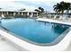 A community pool is surrounded by lounge chairs and landscaped lawns with villas in the background at 6912 10Th W Ave, Bradenton, FL 34209