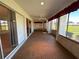 Enclosed lanai featuring sliding glass doors, carpeting, ceiling fan, and view of the yard at 6912 10Th W Ave, Bradenton, FL 34209