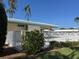 Community pool area with lounge chairs, palm trees, and a white fence at 6912 10Th W Ave, Bradenton, FL 34209