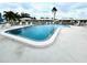 A community pool is surrounded by a white fence, houses, and lounge chairs at 6912 10Th W Ave, Bradenton, FL 34209