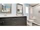 Bathroom with a double sink vanity, walk-in shower and light blue walls at 7019 10Th S St, St Petersburg, FL 33705