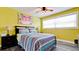 Bedroom with ceiling fan, window, and yellow-painted walls at 7019 10Th S St, St Petersburg, FL 33705