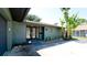 Charming home featuring an entrance with double doors, lush landscaping, and mature palm trees at 7019 10Th S St, St Petersburg, FL 33705