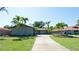 A single-Gathering home with a well-manicured lawn and mature palm trees features a long private driveway at 7019 10Th S St, St Petersburg, FL 33705