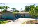 Charming single-story home featuring a well-manicured lawn, mature palm trees, and a private two-car garage at 7019 10Th S St, St Petersburg, FL 33705