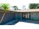 Charming home featuring a private two-car garage, an entrance with double doors, and mature palm trees at 7019 10Th S St, St Petersburg, FL 33705