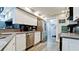 Well-lit kitchen with white cabinets, stainless steel appliances, and tile backsplash at 7019 10Th S St, St Petersburg, FL 33705