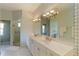 Well-lit bathroom with a double vanity and a doorway leading to another room at 7270 Alicante Dr # 3, Sarasota, FL 34238