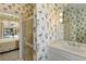 Bathroom with a shower, stylish wallpaper, and well-lit vanity, showcasing a cheerful ambiance at 7270 Alicante Dr # 3, Sarasota, FL 34238