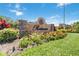 Elegant Prestancia community sign with stone accents and colorful flower bed under a bright blue sky at 7270 Alicante Dr # 3, Sarasota, FL 34238