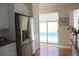 Bright kitchen featuring stainless steel refrigerator and sliding glass doors leading to the pool area at 7270 Alicante Dr # 3, Sarasota, FL 34238