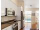Modern kitchen with stainless steel appliances, white cabinetry, and an open design, offering views of the pool area at 7270 Alicante Dr # 3, Sarasota, FL 34238