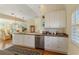 White kitchen with stainless steel dishwasher and hardware, an eat-in bar, and wood-look floors at 7270 Alicante Dr # 3, Sarasota, FL 34238