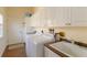 Well-equipped laundry room featuring white cabinetry, modern appliances, and a sink at 7270 Alicante Dr # 3, Sarasota, FL 34238