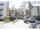 View of the condo's exterior, featuring multiple balconies, palm trees, and landscaped grounds at 7500 40Th W Ave # 209, Bradenton, FL 34209