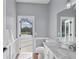 Bright bathroom featuring a marble countertop vanity and a door leading to the pool area at 8015 Panther Ridge Trl, Bradenton, FL 34202