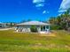 Charming home exterior showcases a serene backyard patio area with seating, overlooking a lush lawn at 8152 Seashell St, Englewood, FL 34224