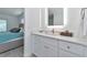 Bright bathroom featuring modern white vanity with quartz countertop, complemented by a well-lit mirror and bedroom access at 8152 Seashell St, Englewood, FL 34224