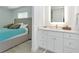 Bathroom vanity featuring white cabinets, quartz countertop, modern fixtures and well lit mirror at 8152 Seashell St, Englewood, FL 34224