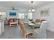 Bright dining area featuring a glass-top table with seating for six, adjacent to a modern living area at 8152 Seashell St, Englewood, FL 34224
