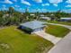 Inviting single-story home with a large front yard and a driveway leading to the attached garage at 8152 Seashell St, Englewood, FL 34224