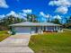 Charming single-story home with a well-manicured lawn and attached two-car garage at 8152 Seashell St, Englewood, FL 34224