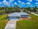 Aerial view of a home displaying a large manicured front lawn, a spacious driveway, and mature trees at 8152 Seashell St, Englewood, FL 34224