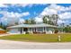 Charming one-story home featuring a two-car garage, a well-manicured lawn, and colorful landscaping at 8152 Seashell St, Englewood, FL 34224