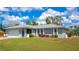 Charming home exterior featuring well-maintained landscaping, a two-car garage, and a covered front porch at 8152 Seashell St, Englewood, FL 34224
