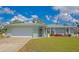 Charming home exterior displaying a well-kept lawn, two-car garage, and a welcoming front entrance at 8152 Seashell St, Englewood, FL 34224