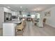 Open-concept kitchen features white cabinets, a mosaic backsplash, stainless appliances, and barstool seating at 8152 Seashell St, Englewood, FL 34224