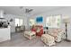 Inviting living area with a cozy seating area, a desk, and ample natural light from the large windows at 8152 Seashell St, Englewood, FL 34224