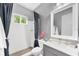 Bright bathroom featuring a tiled shower, stylish wallpaper, and a sleek vanity with a white countertop at 8258 Grande Shores Dr, Sarasota, FL 34240
