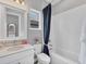 Bathroom with a white vanity, matching fixtures, and shower with a navy curtain at 8258 Grande Shores Dr, Sarasota, FL 34240