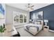 Cozy bedroom with a large window, desk, and decorative blue accent wall at 8258 Grande Shores Dr, Sarasota, FL 34240