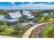Stunning clubhouse with beautifully landscaped grounds, patio seating, and lush greenery under a bright, sunny sky at 8258 Grande Shores Dr, Sarasota, FL 34240