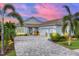 Beautiful single-story home featuring a paver driveway, lush landscaping, and a three-car garage at 8258 Grande Shores Dr, Sarasota, FL 34240