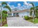 Beautiful single-story home featuring a paver driveway, lush landscaping, and a three-car garage at 8258 Grande Shores Dr, Sarasota, FL 34240