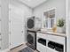 Modern laundry room with stacked washer/dryer, built-in storage, and a bright window at 8258 Grande Shores Dr, Sarasota, FL 34240