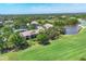 Expansive aerial view of the condo, featuring a lake, golf course, tennis court, and lush trees at 8921 Veranda Way # 325, Sarasota, FL 34238