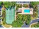 Aerial view featuring a tennis court, swimming pool and clubhouse in a lush setting at 8921 Veranda Way # 325, Sarasota, FL 34238