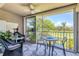 Charming screened-in balcony with seating, ceiling fan, and views of the beautiful green scenery at 8921 Veranda Way # 325, Sarasota, FL 34238