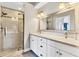 Modern bathroom featuring double vanity, white cabinets, large mirror, and glass enclosed shower at 8921 Veranda Way # 325, Sarasota, FL 34238