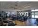 Well-equipped fitness center with machines, weights, and natural light from large windows overlooking pool at 8921 Veranda Way # 325, Sarasota, FL 34238