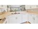 Modern kitchen featuring white cabinets, stainless steel appliances, and bar seating overlooking the living area at 8921 Veranda Way # 325, Sarasota, FL 34238