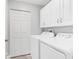 Bright laundry room includes cabinetry and modern appliances at 8921 Veranda Way # 325, Sarasota, FL 34238